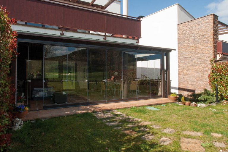 Porche de madera y aluminio con cortinas de cristal Lumon | Proyectos