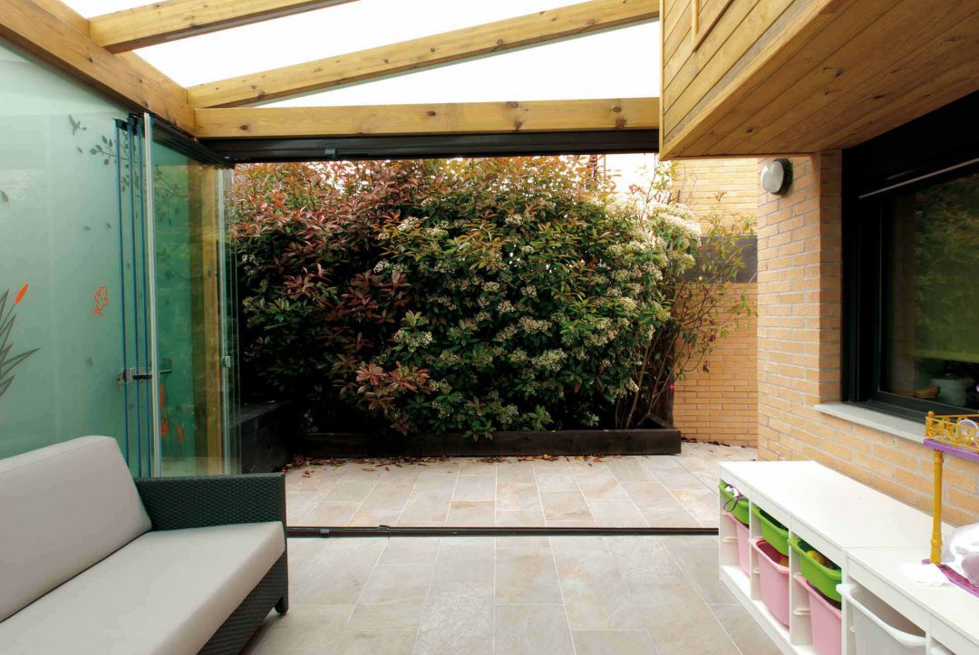 Porche de madera con techo y pared de cristal y cerramiento Lumon