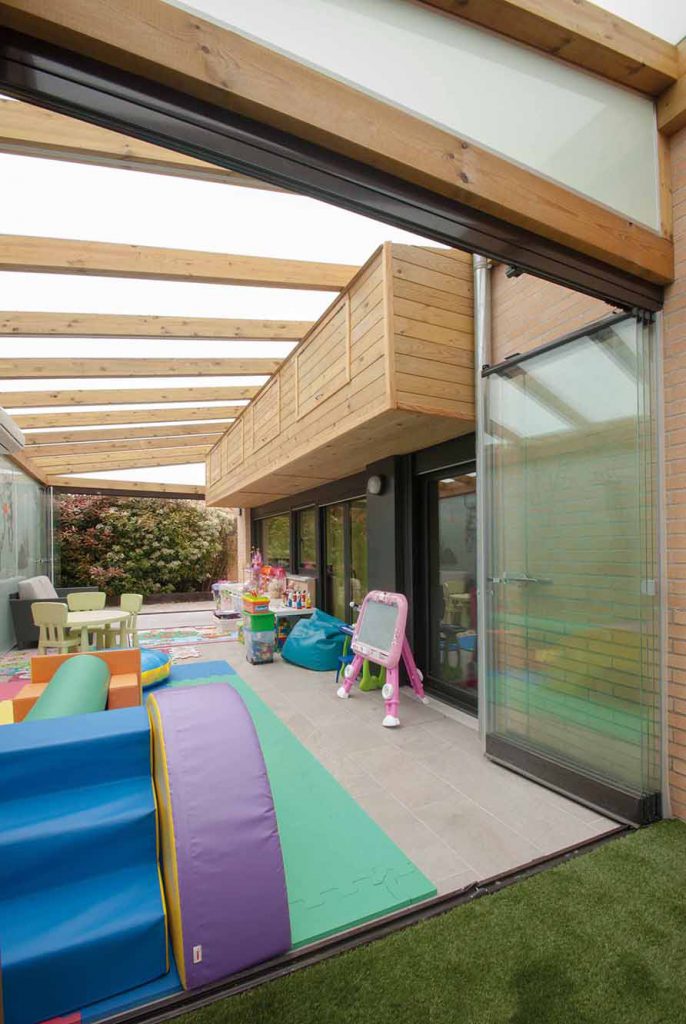 Porche de madera con techo y pared de cristal y cerramiento Lumon