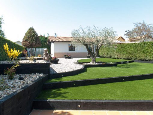 Jardín con césped artificial, traviesas, áridos, jardineras…