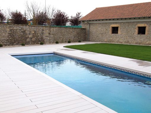 Piscina con tarima exterior y diseño de jardín