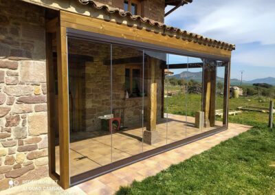 Cortina de cristal en un porche de una casa de piedra