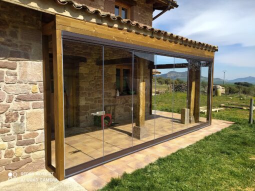 Cortina de cristal en un porche de una casa de piedra