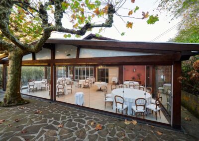 Porche de madera acristalado con cortinas de cristal Lumon en un restaurante de Gipuzkoa