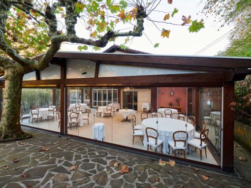 Porche de madera acristalado con cortinas de cristal Lumon en un restaurante de Gipuzkoa